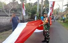Babinsa Pikat Bersama Warga Bentangkan Bendera Sepanjang Ratusan Meter