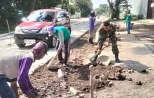 Anggota Koramil Nogosari Bantu Warga Perbaiki Jalan